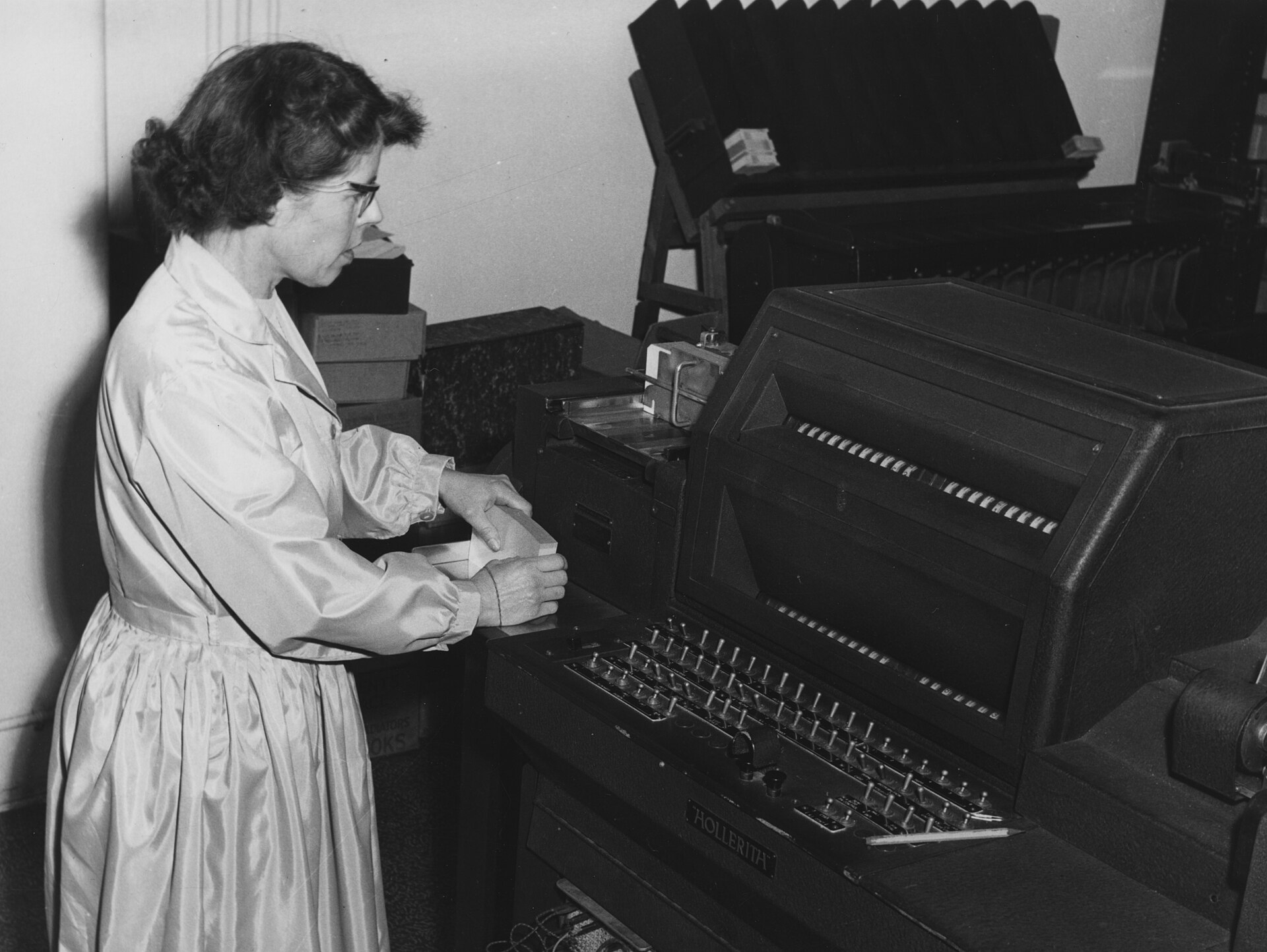 Schwarzweißfoto von 1964: Eine Frau bedient eine Lochkartenmaschine